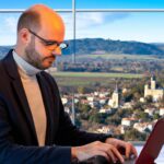 A digital consultant working with a local business in Voiron on their online strategy, with a backdrop of the town's scenic landscapes.